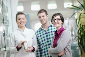 pharmacist suggesting medical drug to buyer in pharmacy drugstore photo