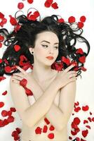 hermosa joven mujer desnuda con rosas aislado en blanco foto