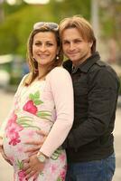 young pregnant couple have fun and relax photo