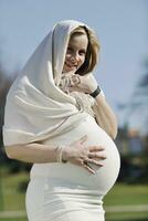 feliz joven mujer embarazada al aire libre foto