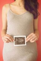 mujer embarazada feliz mostrando imagen de ultrasonido foto
