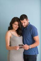 couple looking ultrasound picture isolated on blue background photo