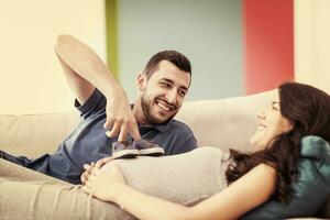 joven pareja embarazada relajándose en el sofá foto