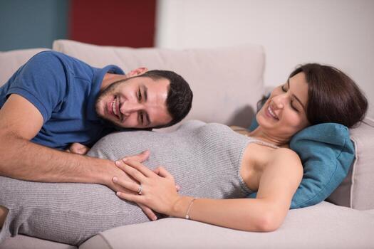 future dad listening the belly of his pregnant wife photo