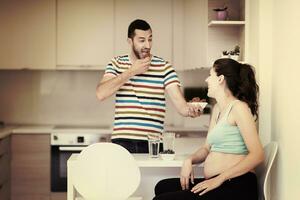 couple eating fruit strawberries at kitchen photo