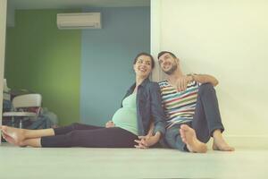 pregnant couple sitting on the floor photo