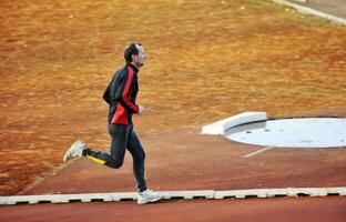 adulto hombre corriendo en atletismo pista foto