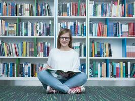 estudiante niña leyendo libro en biblioteca foto