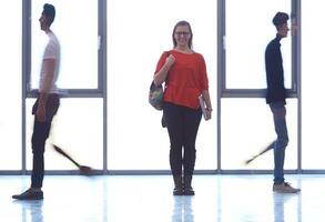 student girl standing with laptop, people group passing by photo