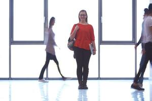 student girl standing with laptop, people group passing by photo