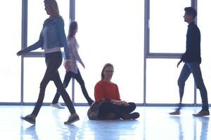 student girl standing with laptop, people group passing by photo