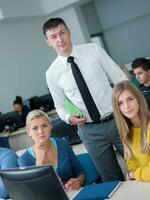 students with teacher  in computer lab classrom photo