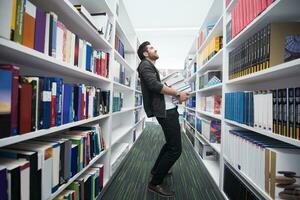 Student holding lot of books in school library photo