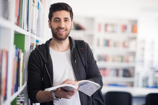 portrait of student while reading book  in school library photo