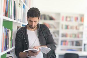 retrato de estudiante mientras lee un libro en la biblioteca escolar foto