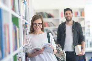 pareja de estudiantes en la biblioteca de la escuela foto