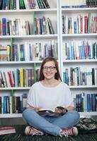 estudiante de famale leyendo un libro en la biblioteca foto