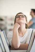 portrait of famale student selecting book to read in library photo