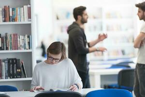 female student study in school library, group of students in background photo