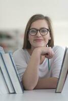 portrait of famale student selecting book to read in library photo