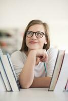 portrait of famale student selecting book to read in library photo