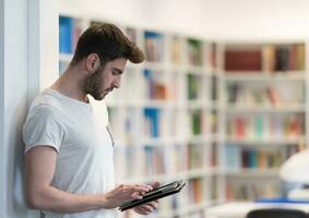 student in school library using tablet for research photo