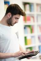 student in school library using tablet for research photo