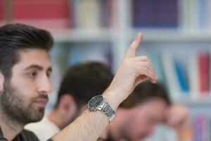 grupo de estudiantes levantan la mano foto