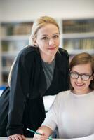 female teacher helping students on class photo