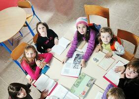 happy kids with  teacher in  school classroom photo