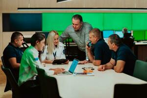 Group of security guards sitting and having briefing In the system control room They're working in security data center surrounded by multiple Screens photo