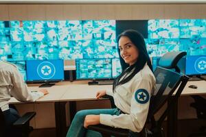 Female security operator working in a data system control room offices Technical Operator Working at workstation with multiple displays, security guard working on multiple monitors photo