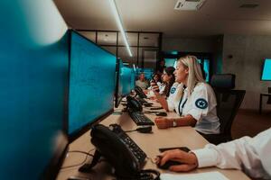 Group of female security operators working in a data system control room Technical Operators Working at workstation with multiple displays, security guards working on multiple monitors in surveillan photo