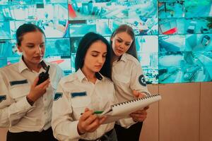 Group of female security operators working in a data system control room Technical Operators Working at workstation with multiple displays, security guards working on multiple monitors in surveillan photo