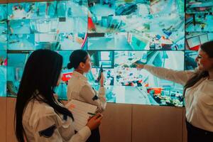 Group of female security operators working in a data system control room Technical Operators Working at workstation with multiple displays, security guards working on multiple monitors in surveillan photo