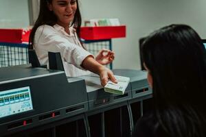 banco empleados utilizando dinero contando máquina mientras clasificación y contando papel billetes dentro banco bóveda. grande cantidades de dinero en el banco foto