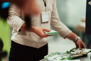 banco empleados participación un pila de papel billetes mientras clasificación y contando dentro banco bóveda. grande cantidades de dinero en el banco foto