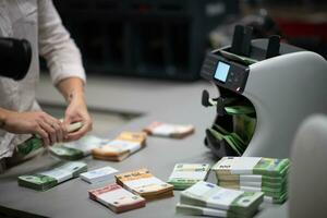 banco empleados utilizando dinero contando máquina mientras clasificación y contando papel billetes dentro banco bóveda. grande cantidades de dinero en el banco foto