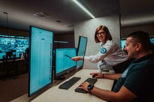 Group of Security data center operators working in a CCTV monitoring room looking on multiple monitors Officers Monitoring Multiple Screens for Suspicious Activities Team working on the System Contr photo