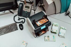 ordenado billetes metido en el mesa después eso es contado en el electrónico dinero contando máquina foto