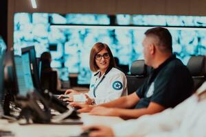 Group of Security data center operators working in a CCTV monitoring room looking on multiple monitors Officers Monitoring Multiple Screens for Suspicious Activities Team working on the System Contr photo