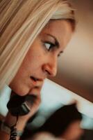 Female security guard operator talking on the phone while working at workstation with multiple displays Security guards working on multiple monitors photo