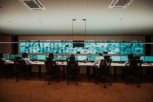 Group of Security data center operators working in a CCTV monitoring room looking on multiple monitors Officers Monitoring Multiple Screens for Suspicious Activities Team working on the System Contr photo