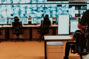 Male security operator working in a data system control room offices Technical Operator Working at workstation with multiple displays, security guard working on multiple monitors Male computer opera photo