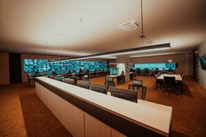 Empty interior of big modern security system control room, workstation with multiple displays, monitoring room with at security data center Empty office, desk, and chairs at a main CCTV security data photo