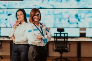 group portrait of female security operator while working in a data system control room offices Technical Operator Working at workstation with multiple displays, security guard working on multiple mon photo