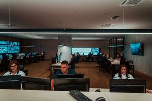 Group of Security data center operators working in a CCTV monitoring room looking on multiple monitors Officers Monitoring Multiple Screens for Suspicious Activities Team working on the System Contr photo