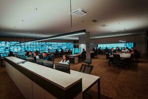 Group of Security data center operators working in a CCTV monitoring room looking on multiple monitors Officers Monitoring Multiple Screens for Suspicious Activities Team working on the System Contr photo