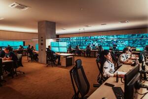 Group of Security data center operators working in a CCTV monitoring room looking on multiple monitors Officers Monitoring Multiple Screens for Suspicious Activities Team working on the System Contr photo