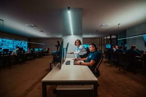 Group of Security data center operators working in a CCTV monitoring room looking on multiple monitors Officers Monitoring Multiple Screens for Suspicious Activities Team working on the System Contr photo